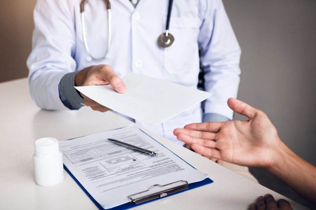 doctor in white scrubs handing over paperwork nhs privatisation